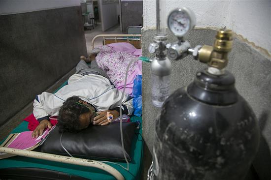 当地时间2021年5月5日，尼泊尔加德满都，一名新冠患者在医院的急诊走廊上吸氧。澎湃影像 图